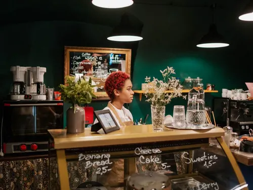 Mitarbeiterin hinter der Theke eines hellen Cafés